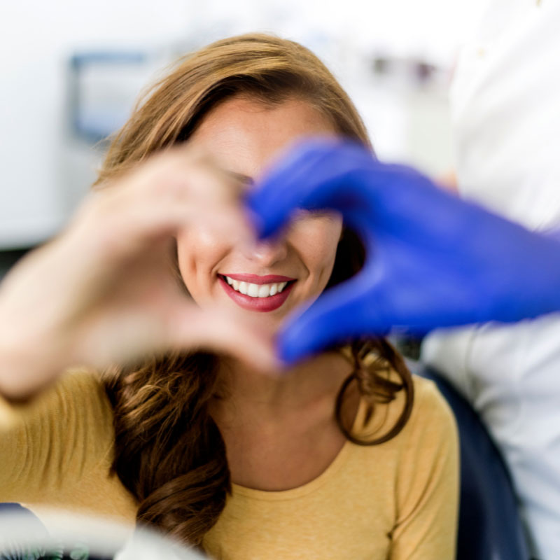 como-contratar-fidelizacion-de-pacientes-clinicas Dentista y paciente haciendo un corazon
